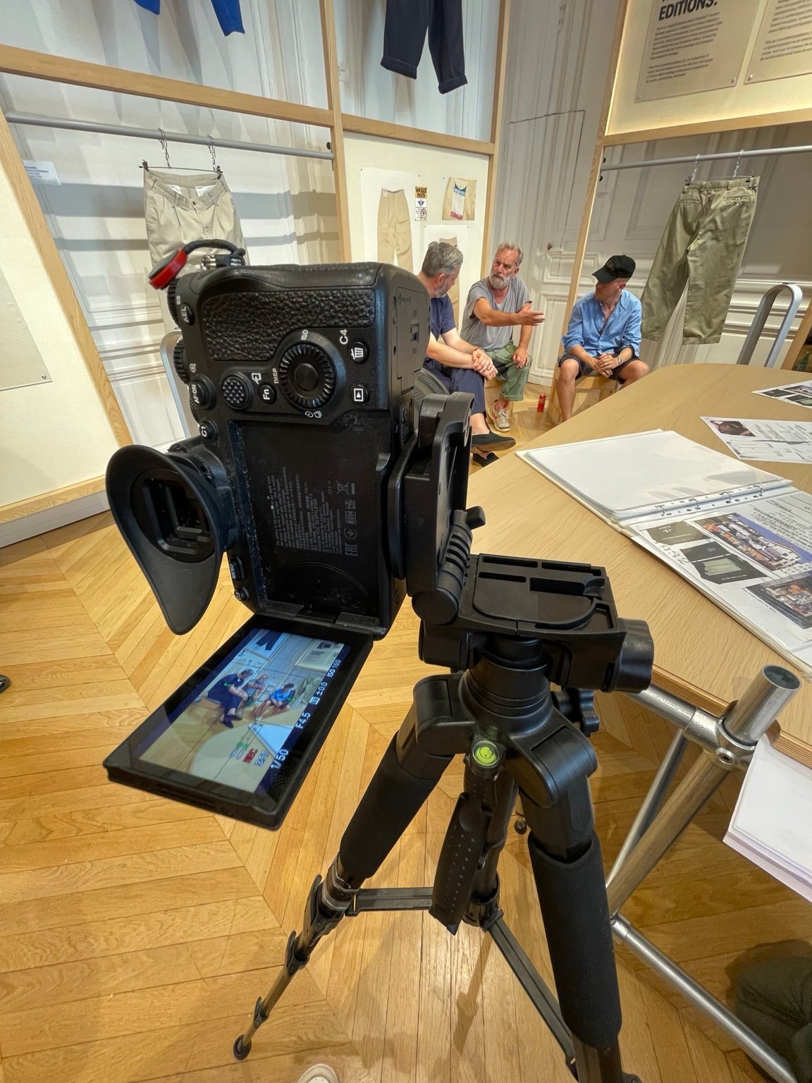 Camera crew filming a conversation in a clothing studio